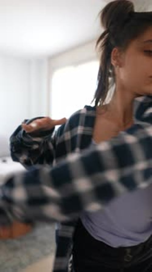 Young Woman Dancing in Flannel Shirt and Shorts