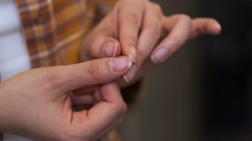 Frau demonstriert gepflegte trockene Nägel und Nagelhaut