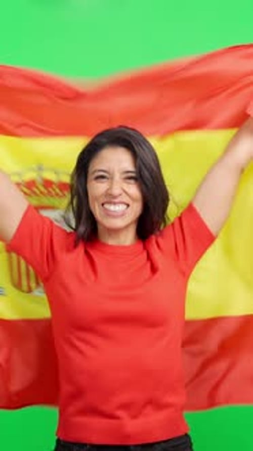 Excited woman holding the Spanish flag on green screen