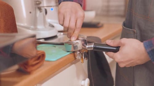 Barista Tamping Coffee in Portafilter Close Up