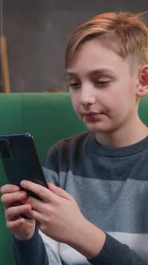 Blonde Boy Using Mobile Phone at Home