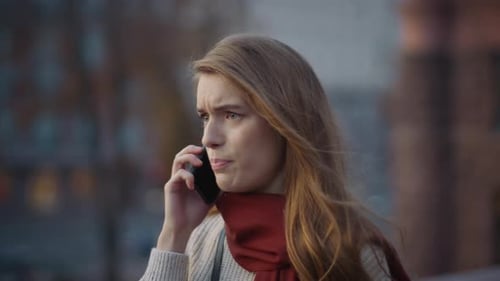 Upset woman talks on phone in city