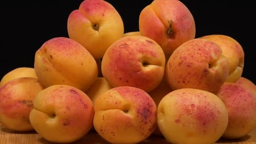 Pile of Fresh, Yellow Apricots on Wooden Surface