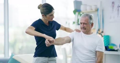 4k video footage of an attractive young female physiotherapist working with a senior male patient