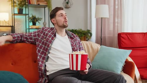Man Watches With Interest, Eating Popcorn