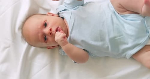 Infant Lying on White Blanket