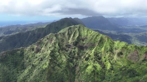 Drone aerial view of Oahu, Hawaii, over lush mountains.