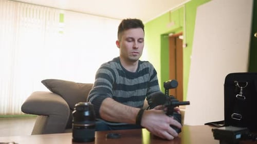 Man Assembling Camera Lens in Brightly Lit Room
