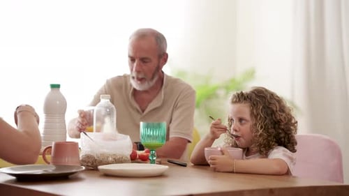 Family Mealtime: Grandfather, Child, and Adult Enjoying Breakfast