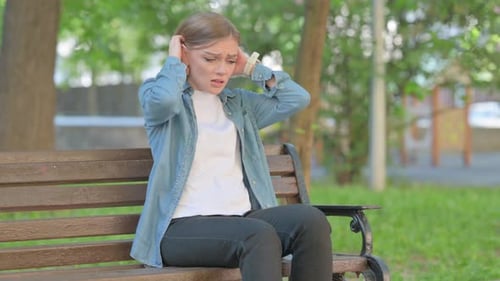 Distraught Woman Sitting on Park Bench