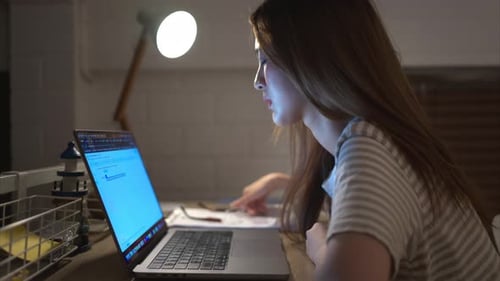 A young woman works on her laptop at home. It is characterized with headaches