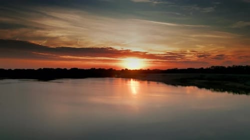 The Flight Above the Lake in Park on a Sunset Background