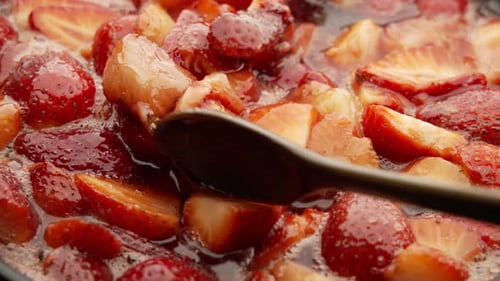 Cooking Strawberries in Sweet Glaze with Wooden Spoon