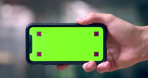 4k video footage of an unrecognizable person holding a mobile phone with a green screen