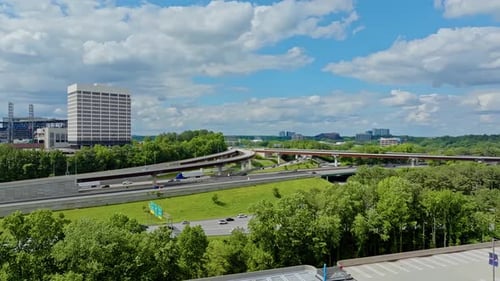 Traffic scene with trucks and cars in american suburb. Overpass highway with green trees and clouds
