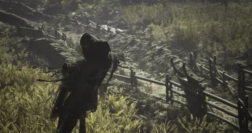 Scarecrow Standing in a Misty Field Surrounded By Tall Crops and a Fence