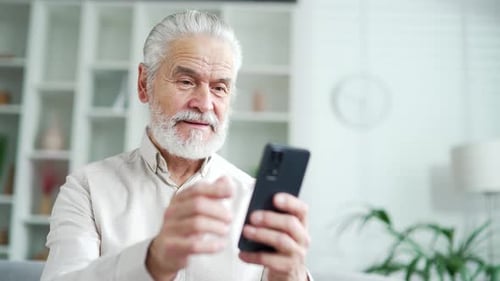 Senior Man Using Smartphone in Modern Home