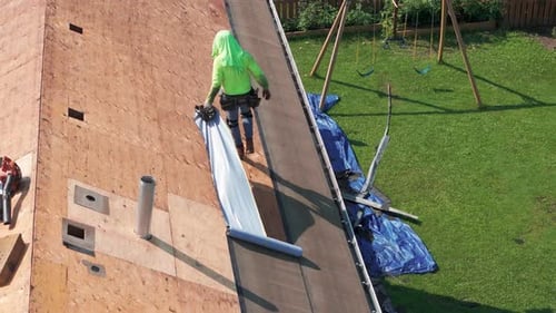 Roofer Installing a New Roof on an House Element of Work Moments