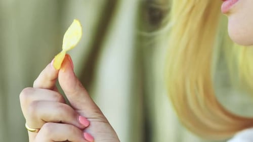 Blonde Girl Eating Chips on the Street