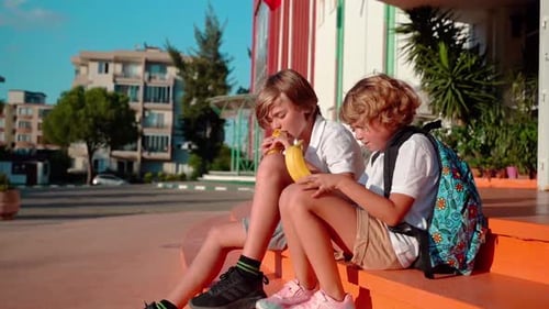 Students Eating Lunch in School Yard During Break Sitting on the Porch
