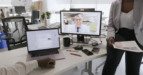 Business People Video Conferencing at Computer in Open Plan Office Business