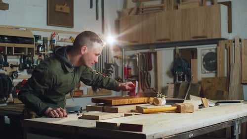 A Male Carpenter Checks the Dimensions of a Product with a Ruler in His Workshop