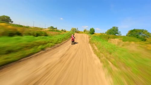 Motorcycle Rider Navigating a Dirt Track on Sunny Day