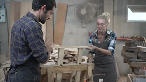 Carpenters are working together at workshop.