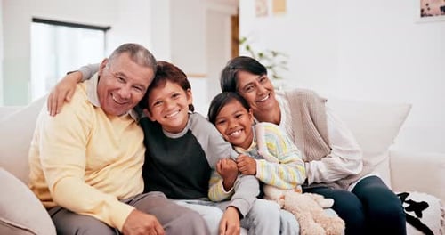 Smiling Family Poses Together on White Couch Indoors