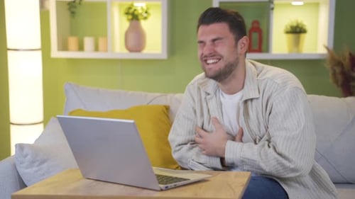 The man watching the comedy movie starts to laugh when the funny scene comes.