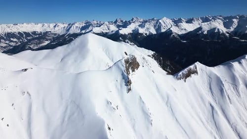 the camera flies towards a snow-covered white mountain. the background is full of more big mountains