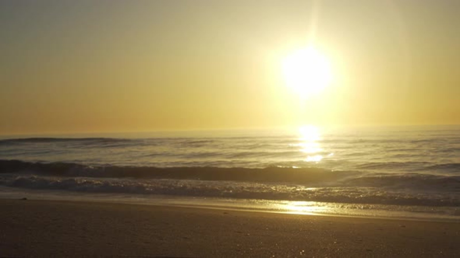 Pôr do sol panorâmico sobre a paisagem da praia, ondas batendo no ...