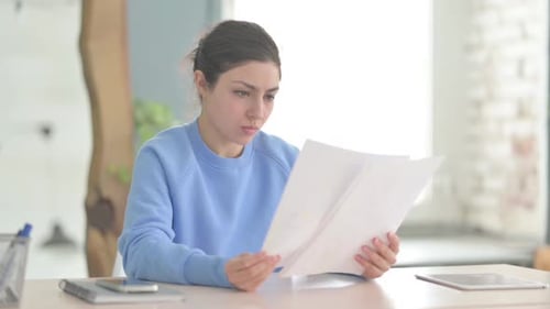 Indian Woman Reading Documents in Office, Paperwork