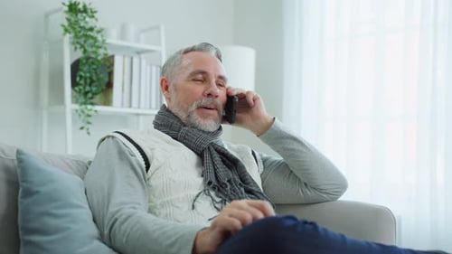 Man Talking on Cellphone While Sitting on Couch