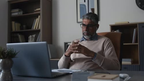 Man Video Conferencing at Desk in Home Office