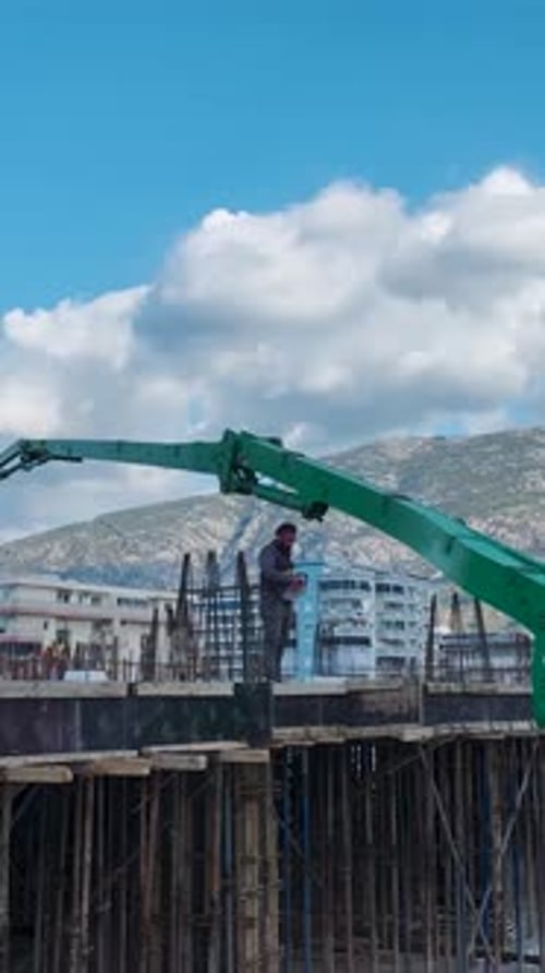 Vertical Video Construction Workers Shaping a Residential Tower with Precise Concrete Pouring