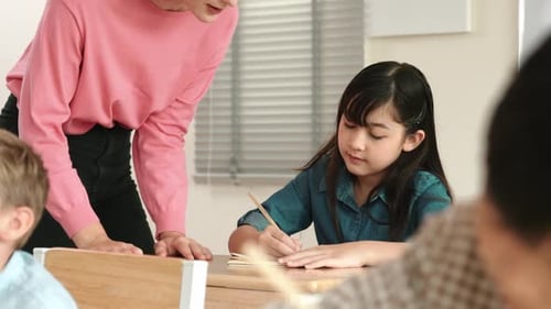 Girl writes in notebook at her school desk