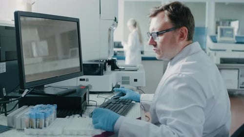 Medical Professional Working at Computer in Modern Lab