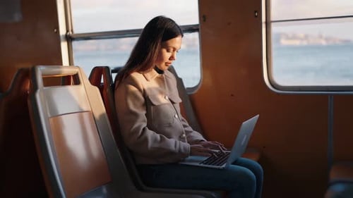 Young Woman Using Laptop on Morning Ferry Commute