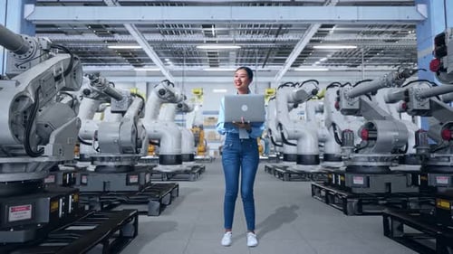 Woman Using Laptop in Robot Manufacturing Factory