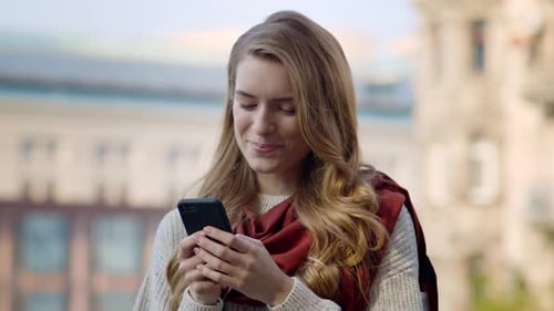 Smiling Woman Using Mobile Phone Outdoors in City