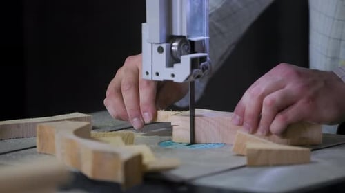 A man works with wood in a workshop. Working with wooden blanks. A man drills holes in wooden blanks
