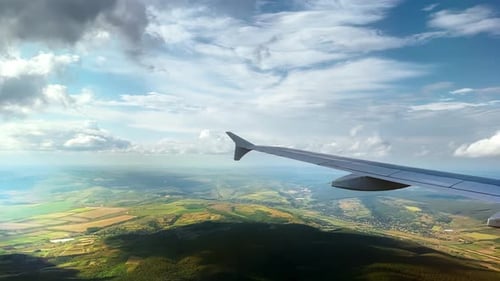 Wing of an airplane during a flight above the fields