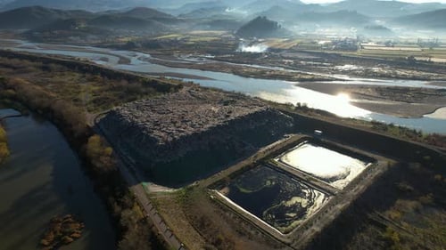 Pile of garbage at landfill, dump of unsorted waste and large pits with dirty contaminated water