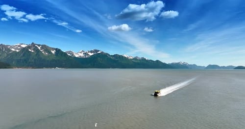 Boat Moving Across Calm Water Under Blue Sky