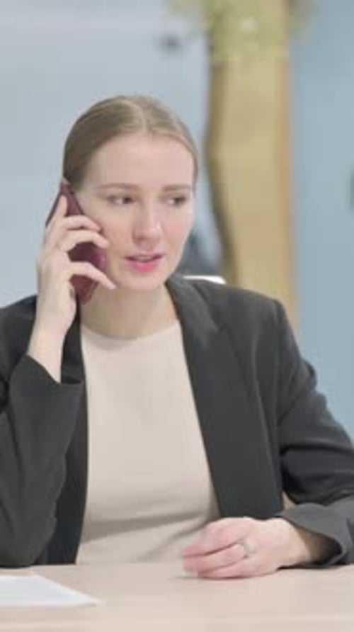 Business Woman Talking on a Mobile Phone at Work
