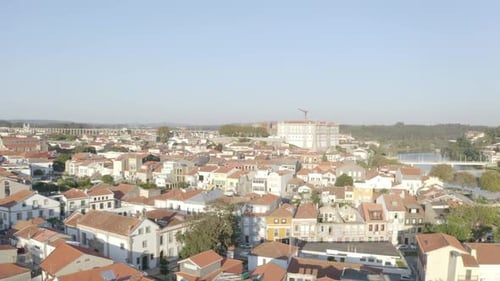 Drone view descending over an antique villa in Portugal, revealing a cluster of houses during sunset