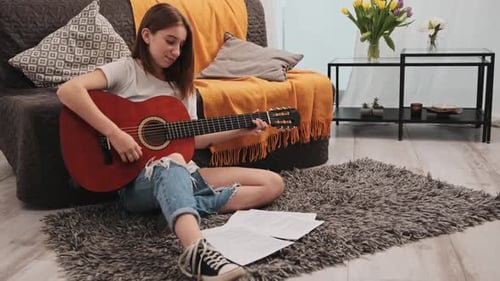 Young Person Playing Acoustic Guitar Indoors