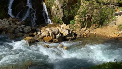 Wasserfall, der neben Felsen im Wald fließt