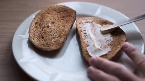 Butter Being Spread on Toast Slices
